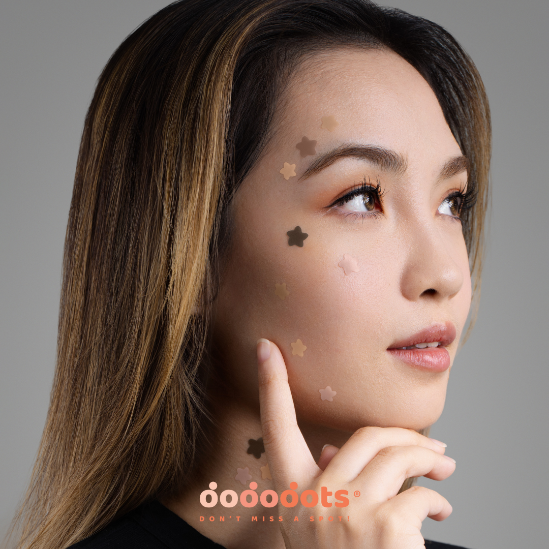 Woman resting her chin on her hand, wearing skin-tone star-shaped Dododots pimple patches on her cheek and jaw