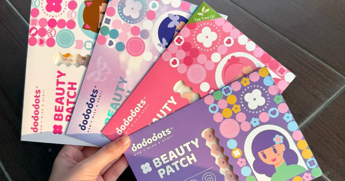 Hand holding four colourful Dododots pimple patch packs fanned out to compare designs
